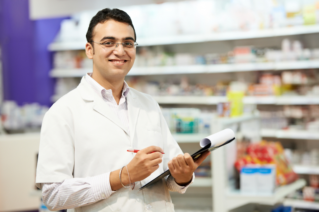 cheerful pharmacist chemist woman standing in pharmacy drugstore